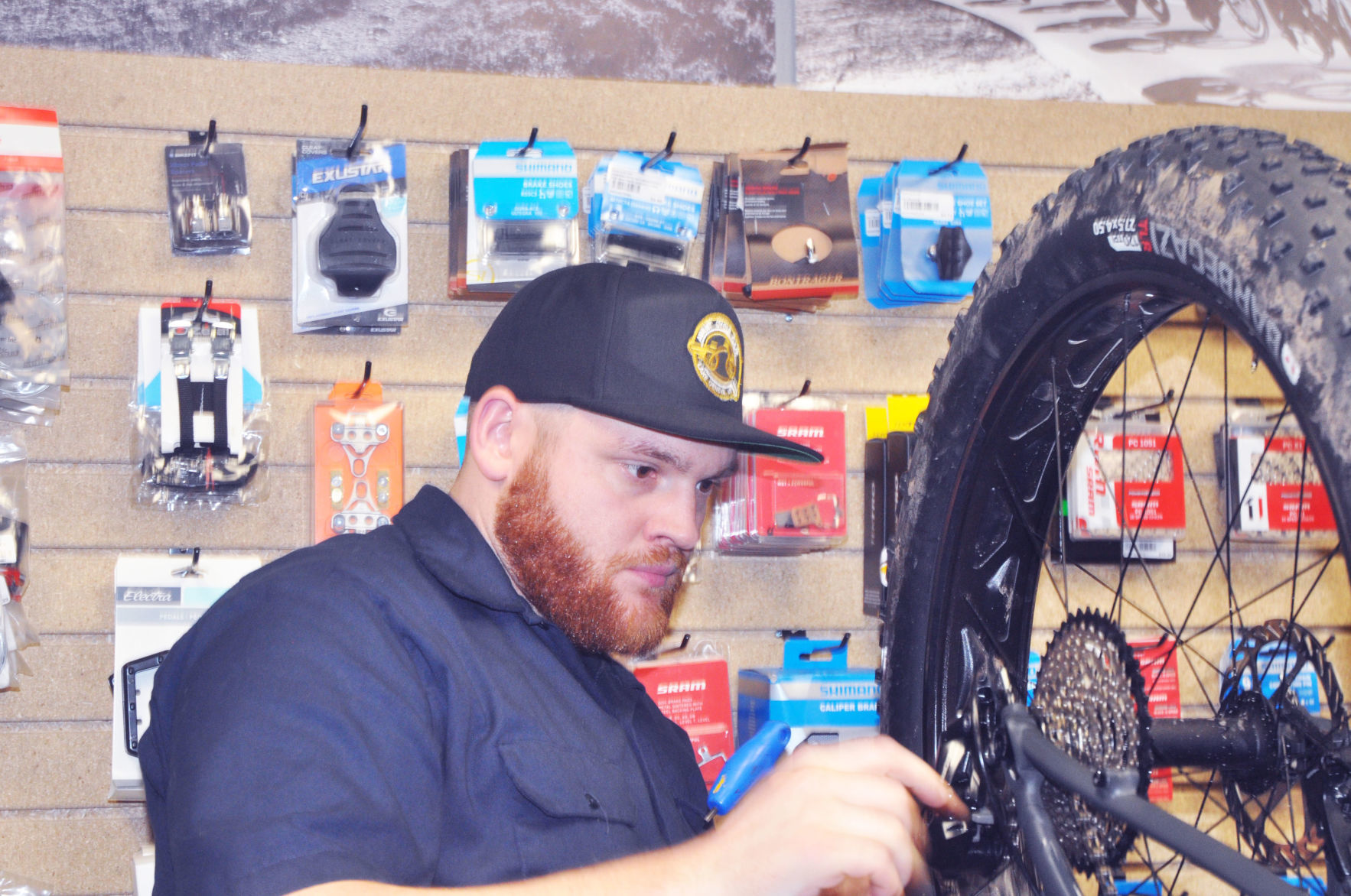 Michael Winters, Avant Cycle Cafe employee, repairs a bicycle at Avant